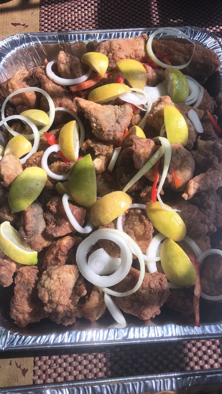 Golden fried pieces with lime wedges and onion rings