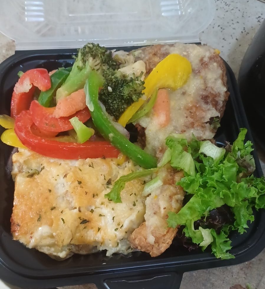 A packed lunch box with baked pasta, peppers and greens